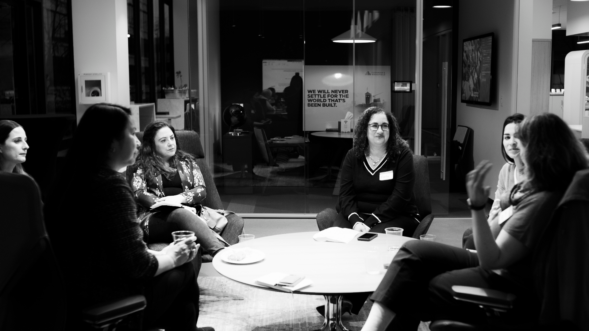 Audience seated around a conference table during a WAAC presentation.