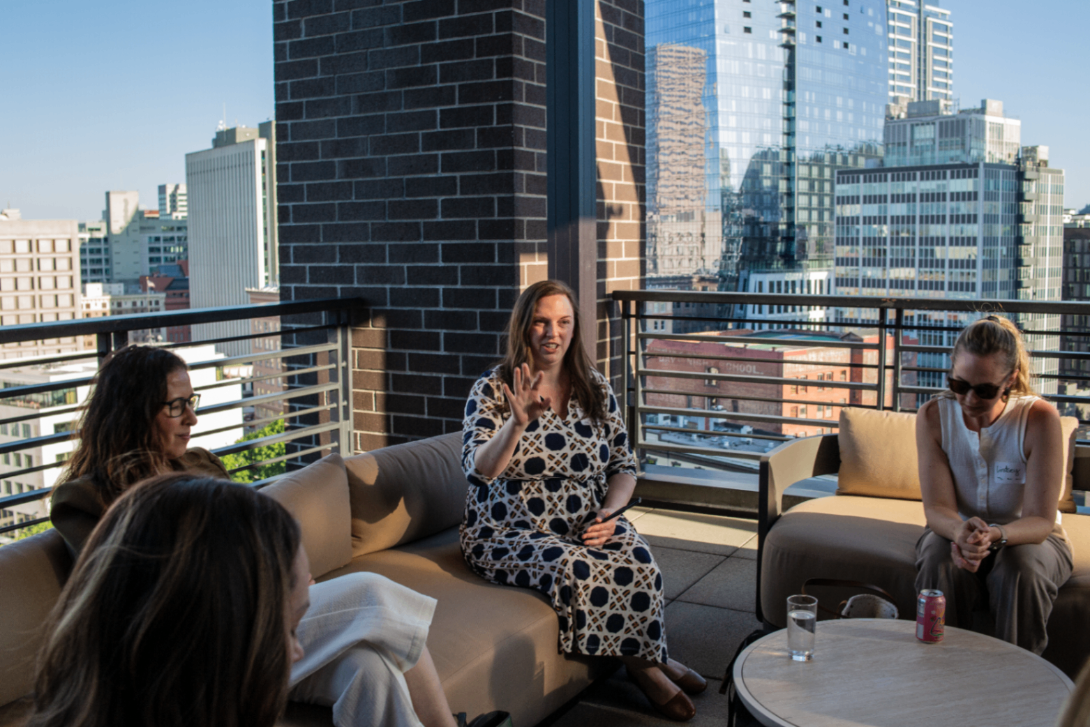 Small rooftop gathering of attendees in conversation overlooking downtown Portland.