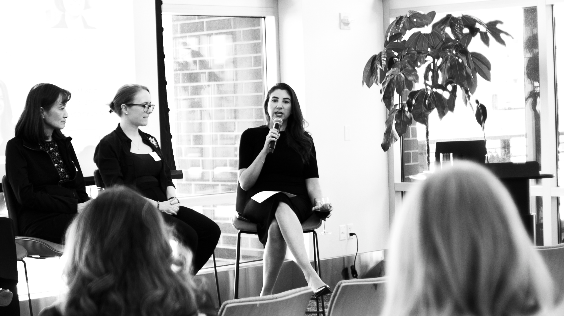 Panel discussion with a speaker holding a microphone at a WAAC event.