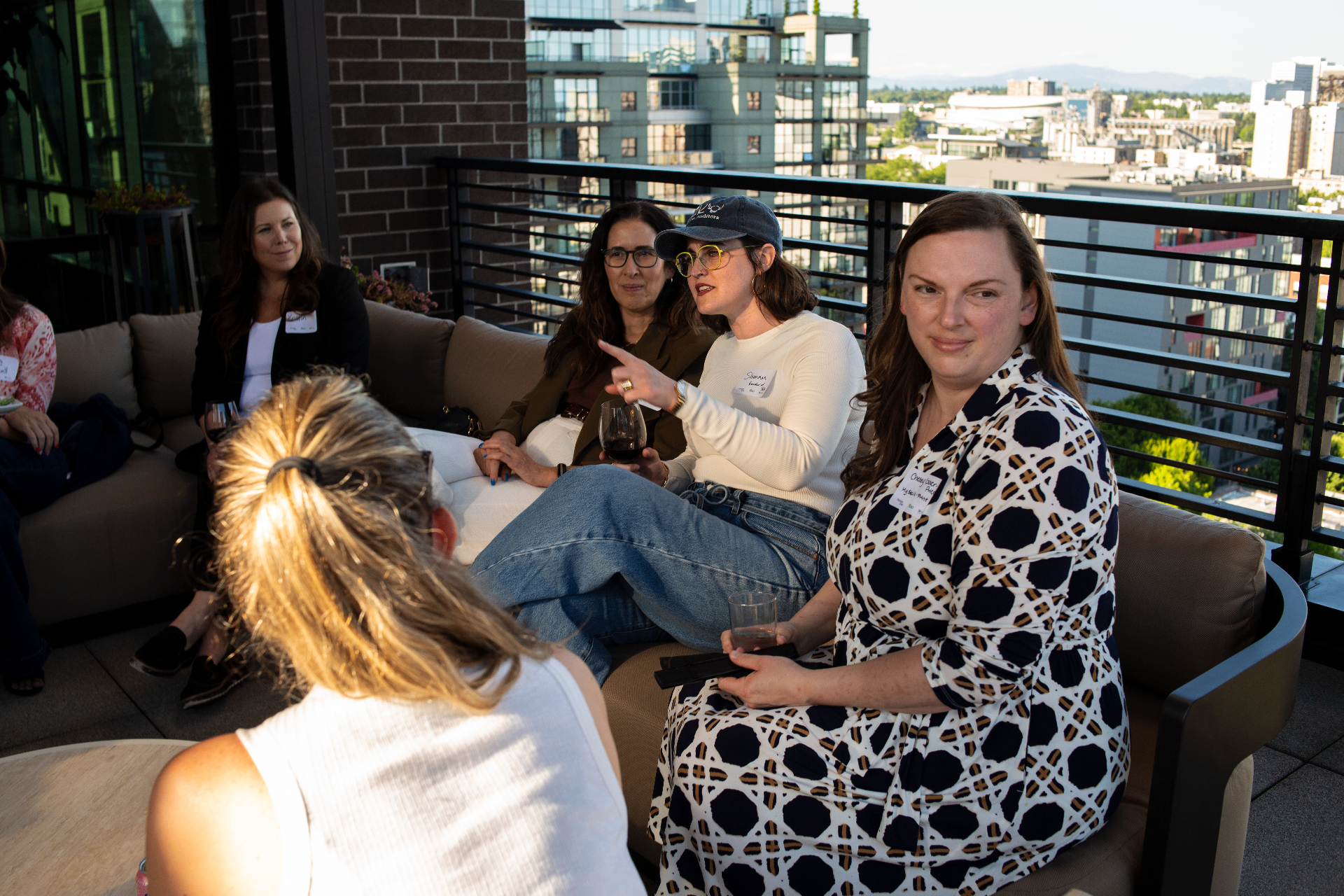 WAAC attendees in conversation on a Portland rooftop at golden hour.